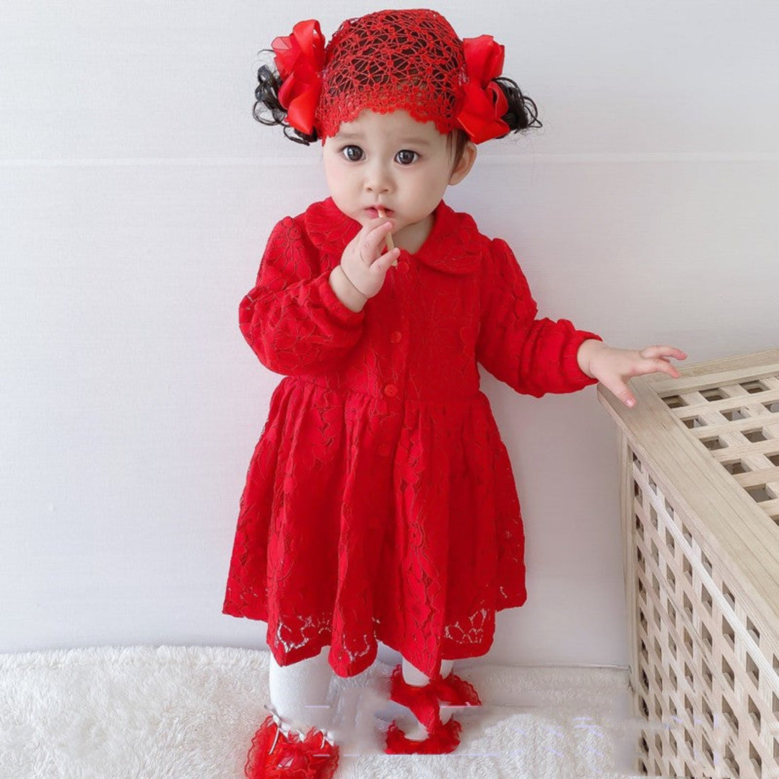 Close-up of a red baby girl dress with delicate lace and a cute bow.