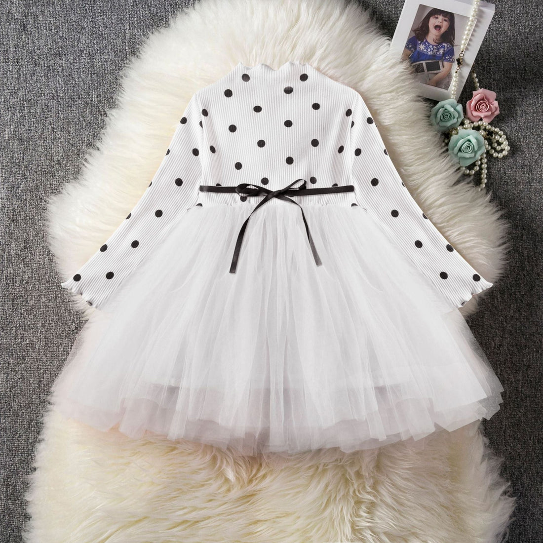 A baby girl wearing an elegant long sleeve tutu lace dress in white color.