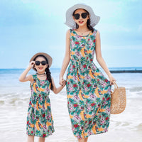 Mother and daughter enjoying beach vacation in matching vest and long skirt outfits