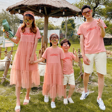 Family wearing matching summer outfits in a park