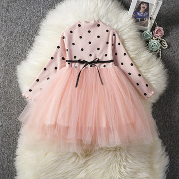 A baby girl wearing an elegant long sleeve tutu lace dress in pink color.
