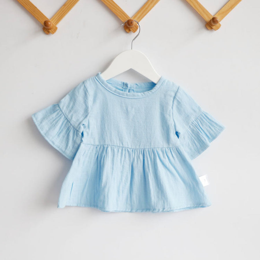 Close-up of a baby girl's cotton shirt in blue colors.