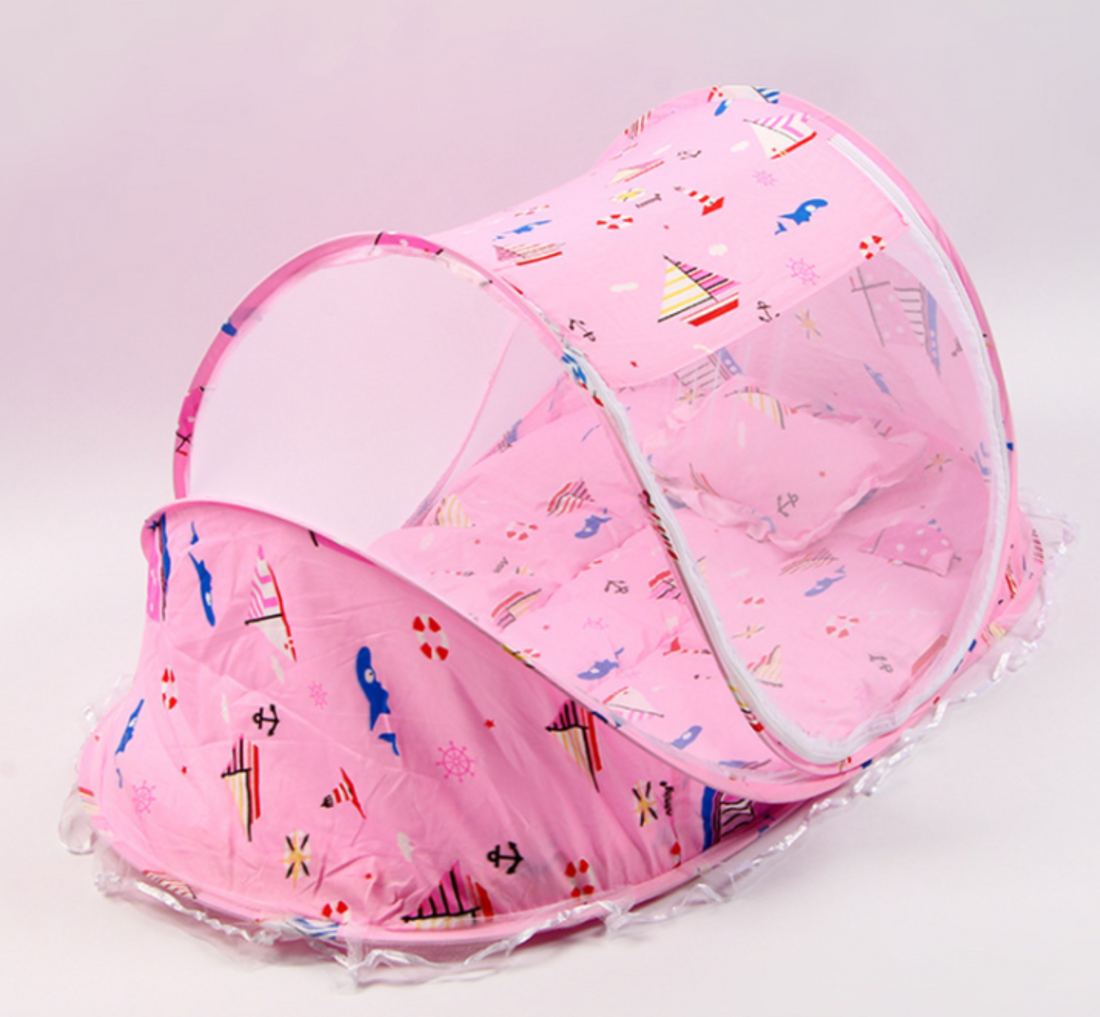 Pink baby bed with pillow and mosquito net