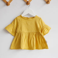 A baby girl in a comfortable shirt, perfect for everyday wear.
