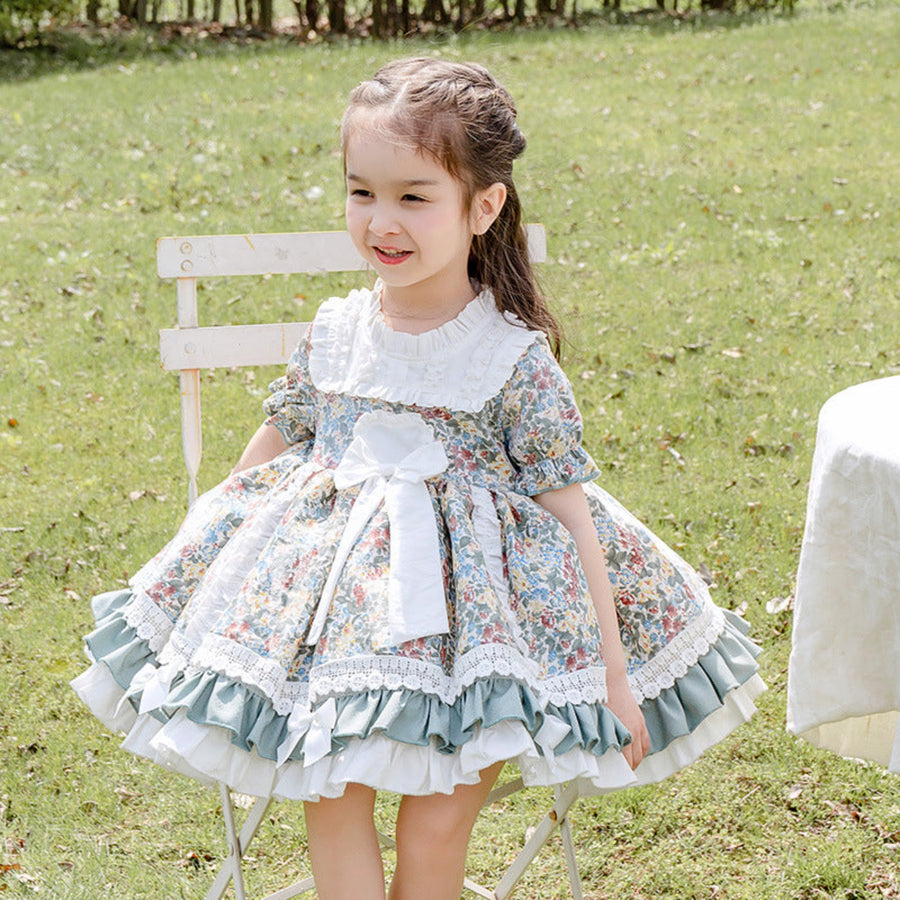 Side view of a baby girl in a short sleeve floral dress, perfect for summer.