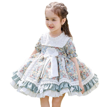 A baby girl wearing an adorable floral dress with short sleeves.