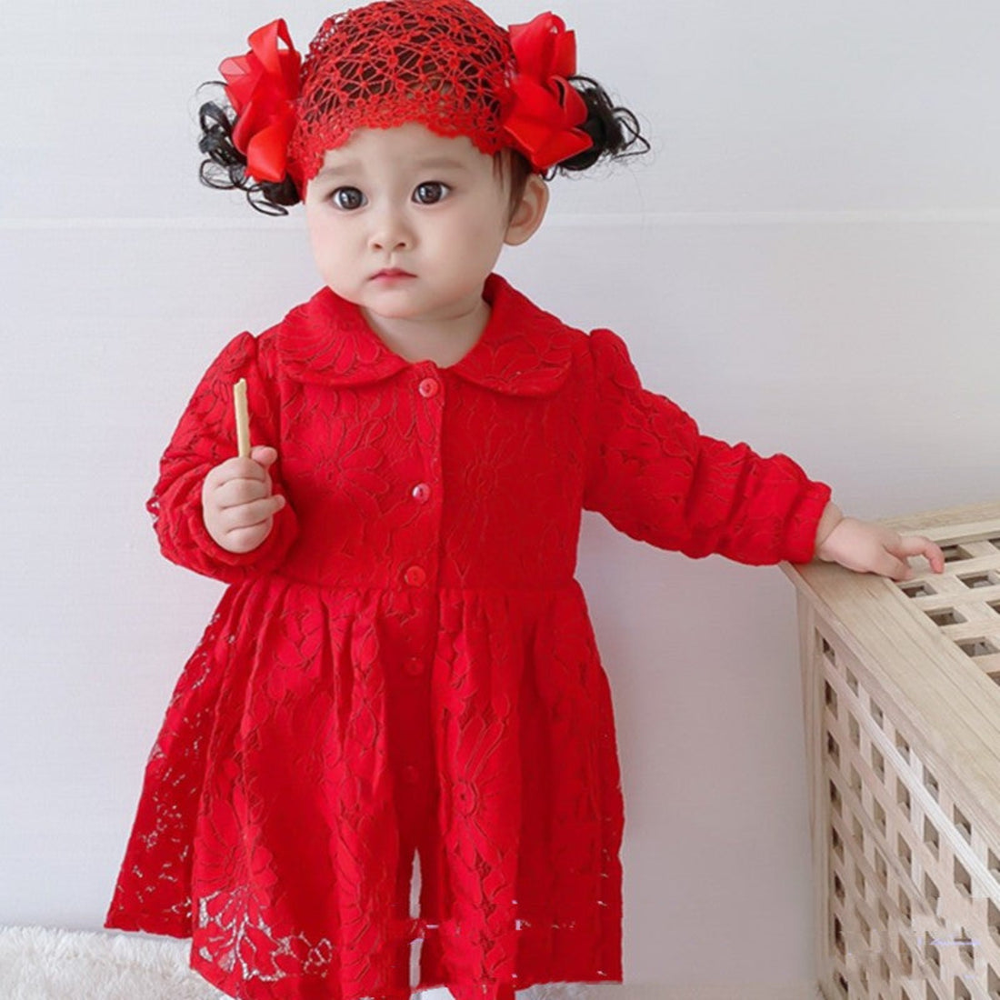 Newborn girl in a red dress, perfect for full moon parties and celebrations.
